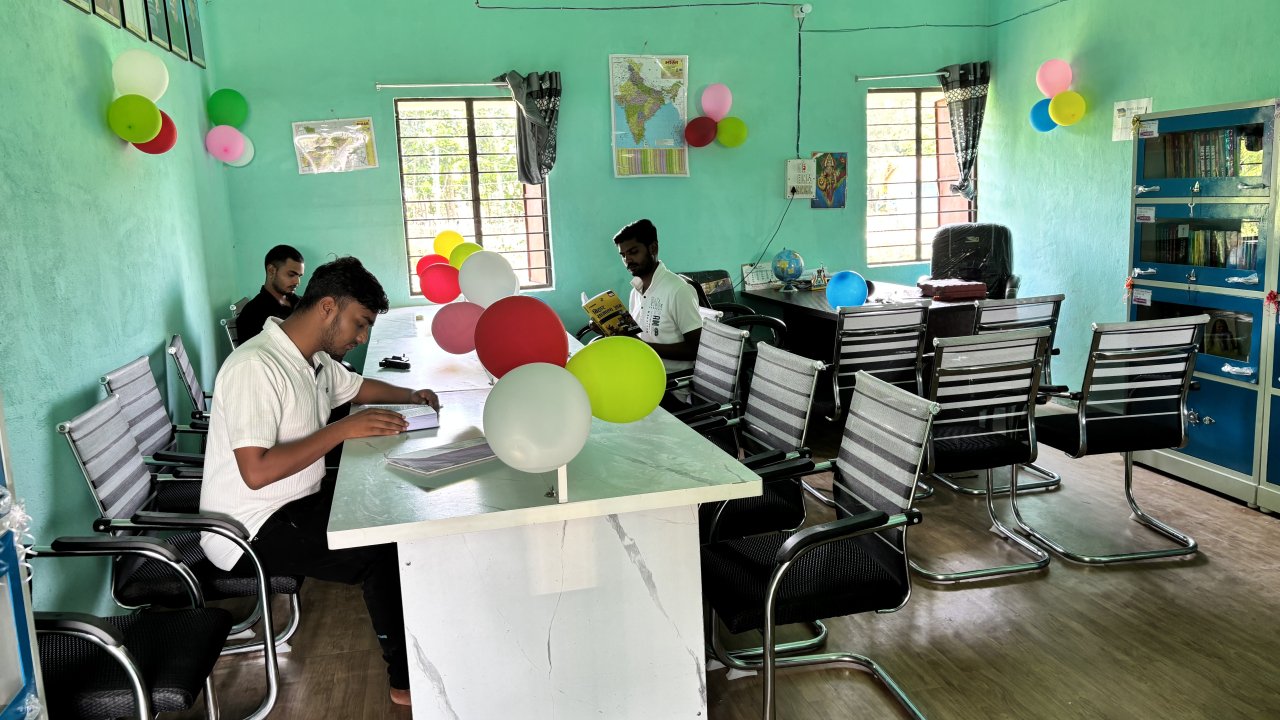 Students reading reference books and educational materials in a community library in India