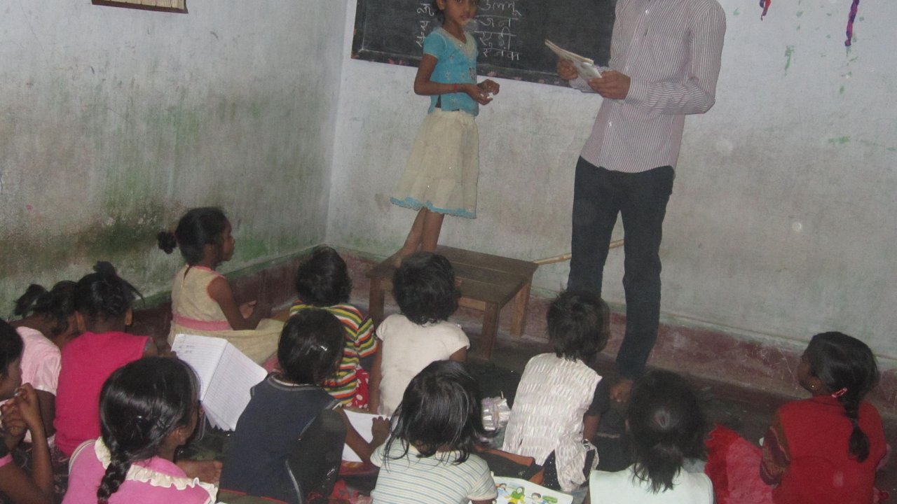Volunteer mentor interacting and teaching community students at a learning center in India